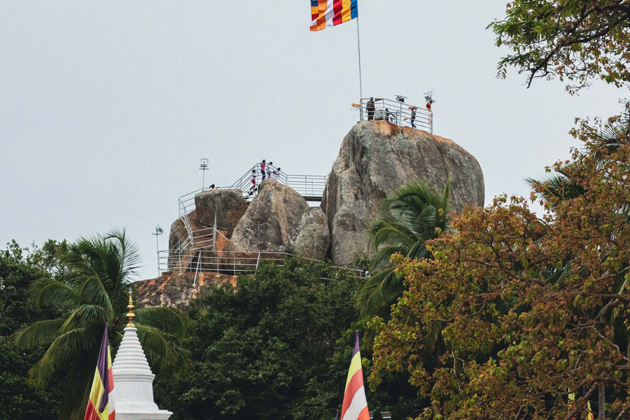 Mihintale stupa and rock formations with Buddhist flags, Sri Lanka