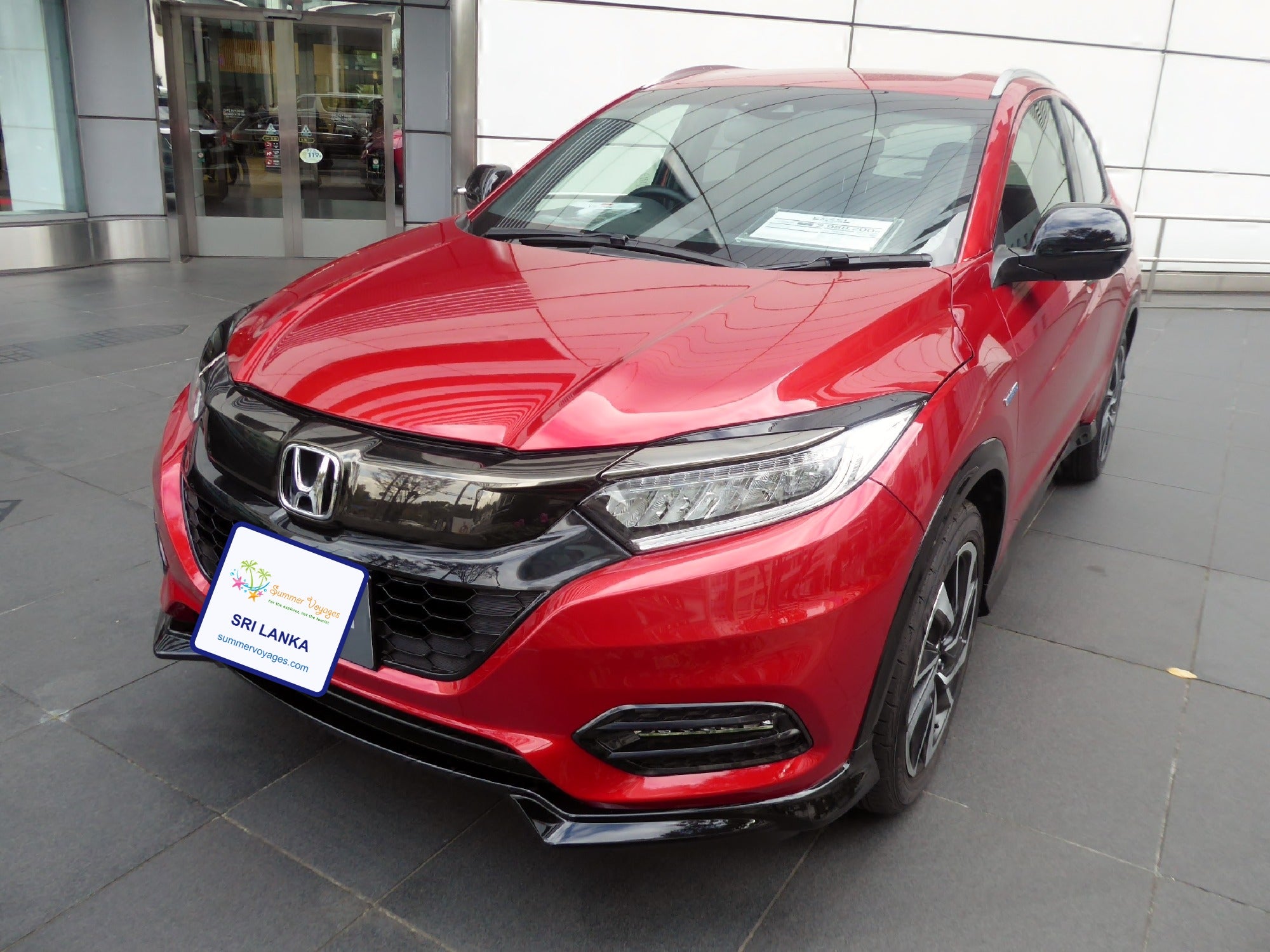 Honda Vezel compact SUV with Summer Voyages branded plate, representative image (base photo: Tokumeigakarinoaoshima, CC BY-SA 4.0, Wikimedia Commons, modified)